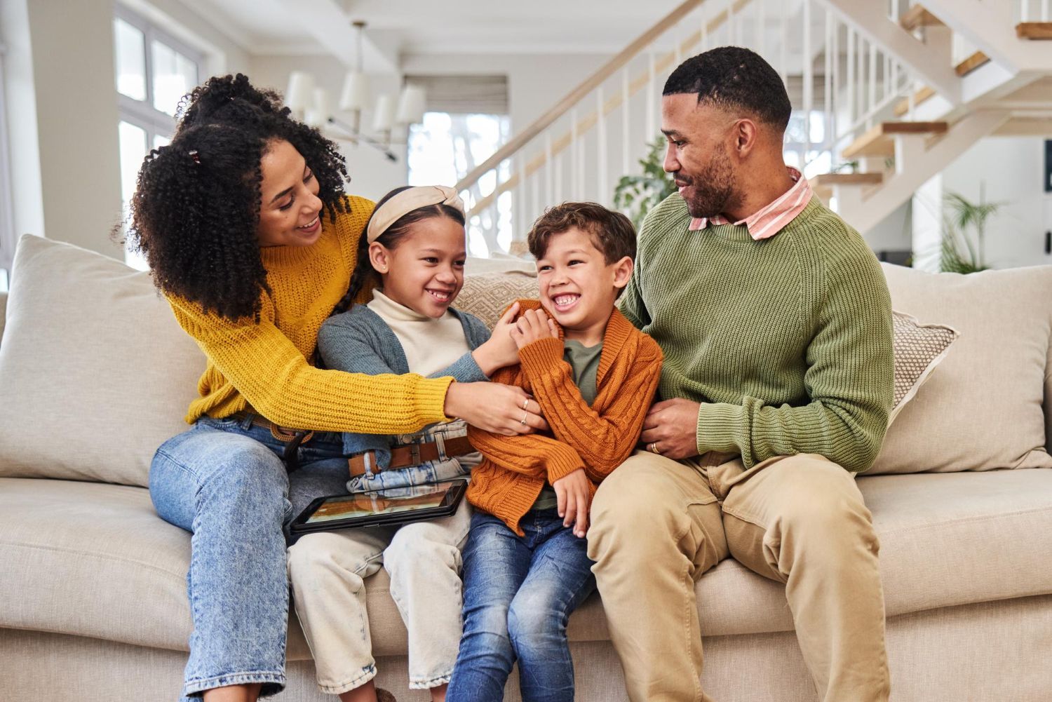 A family is sitting on a couch in a living room.