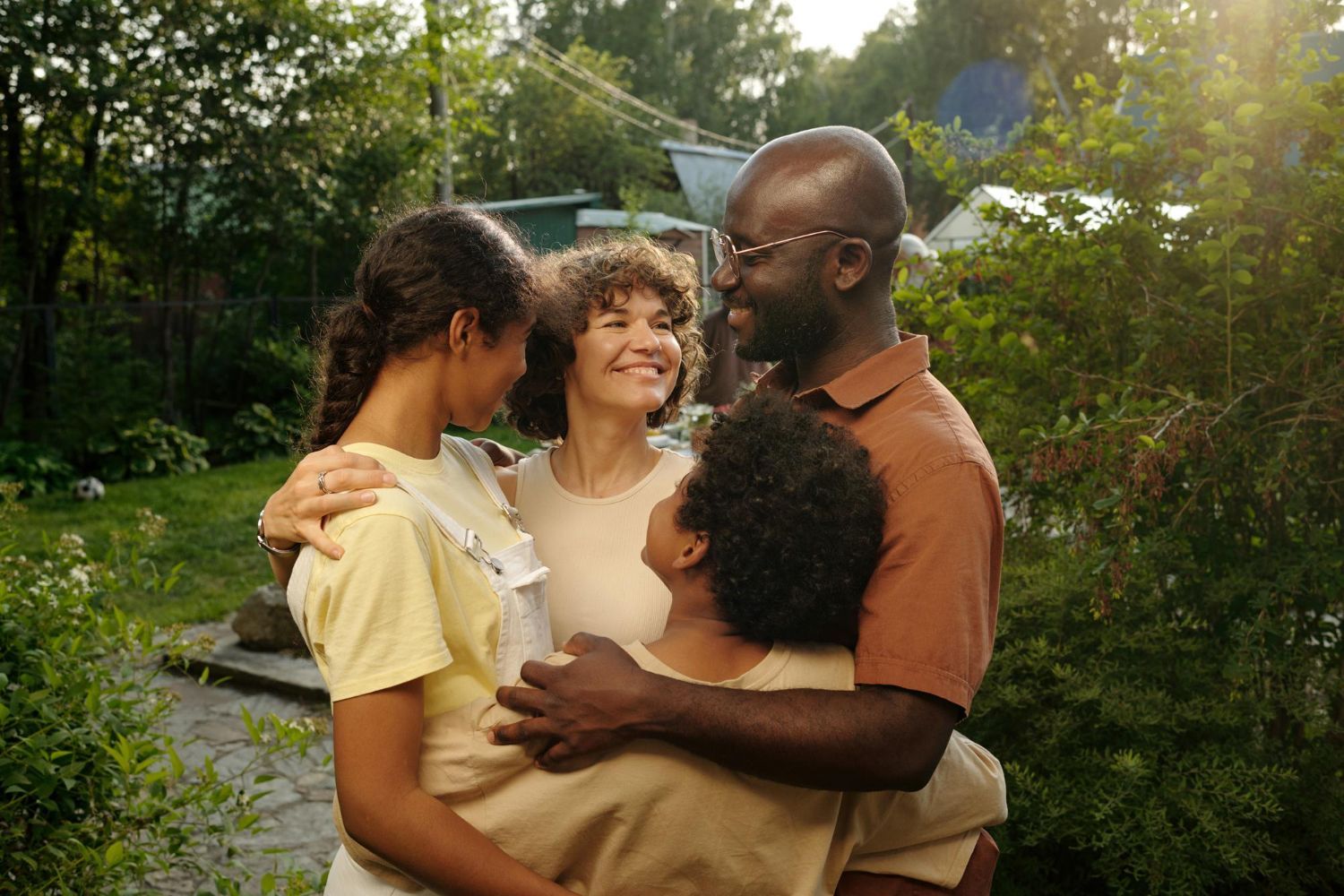 A family is hugging each other in a garden.