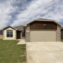 A house with a garage and a driveway in front of it.