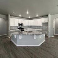 A kitchen with a large island and granite counter tops.