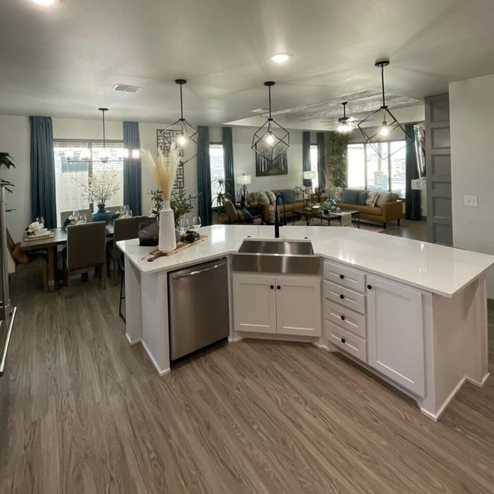 A kitchen with white cabinets and a stainless steel sink