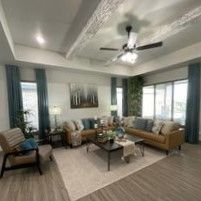 A living room filled with furniture and a ceiling fan.