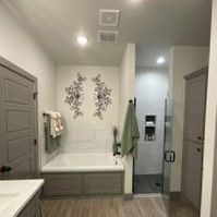 A bathroom with a tub , sink , and shower.