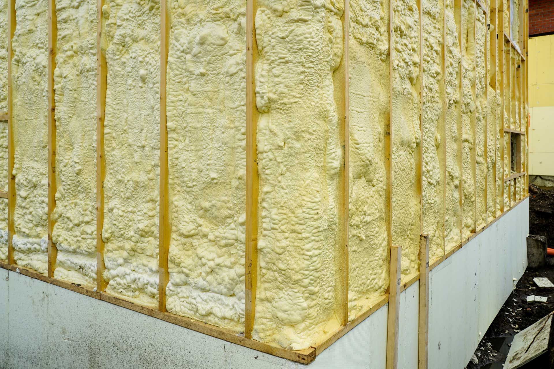 Exterior wall with insulation applied between wooden studs.