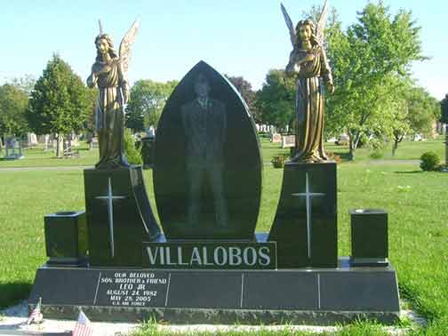 Black granite headstone with etched figure, angels, and name 