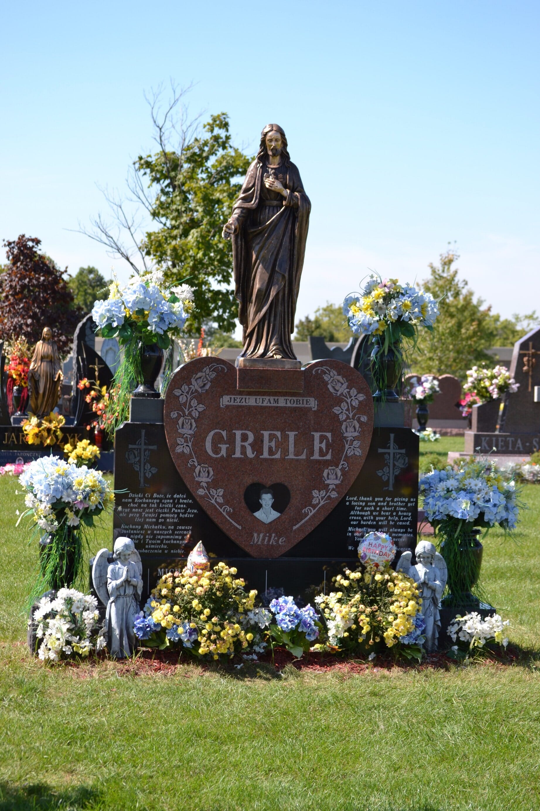 Gravestone with statue of Jesus, heart-shaped marker with 