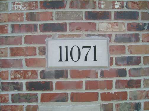 Brick wall with a rectangular address plaque displaying the number 11071.