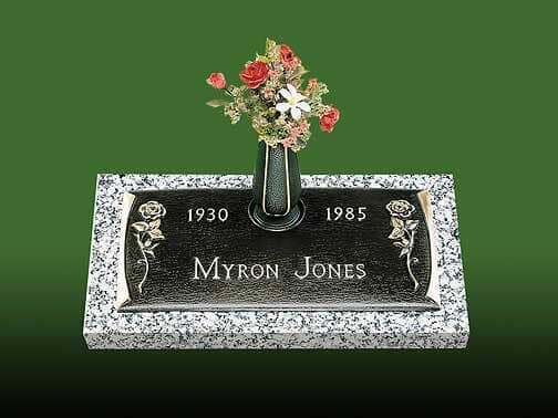 Headstone of Myron Jones, granite with flowers, dates 1930-1985, roses.