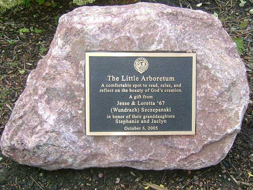 Plaque on a large red-brown rock reads
