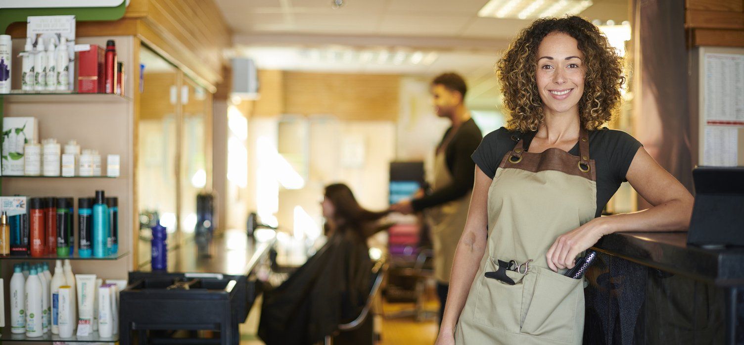 Female business owner standing in front of her salon - showing the use of effective content marketing strategies to attract customers.