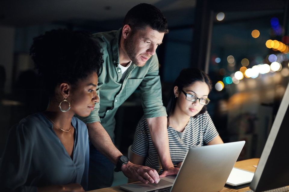 Group of business owners in an office using a laptop to manage their online business.