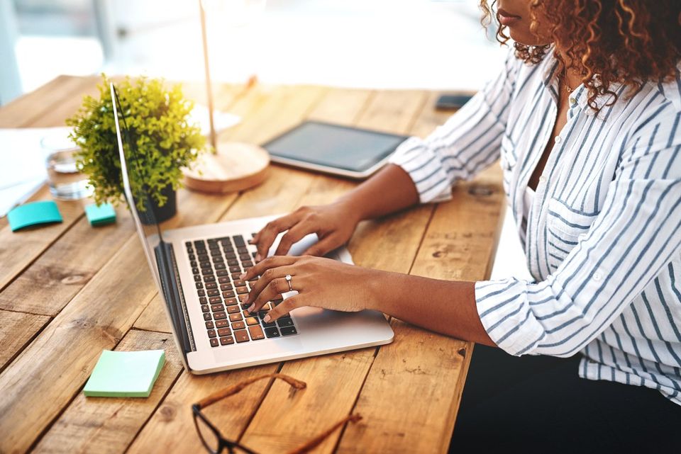 Woman typing on a laptop and planning for her new online business during the worldwide pandemic.