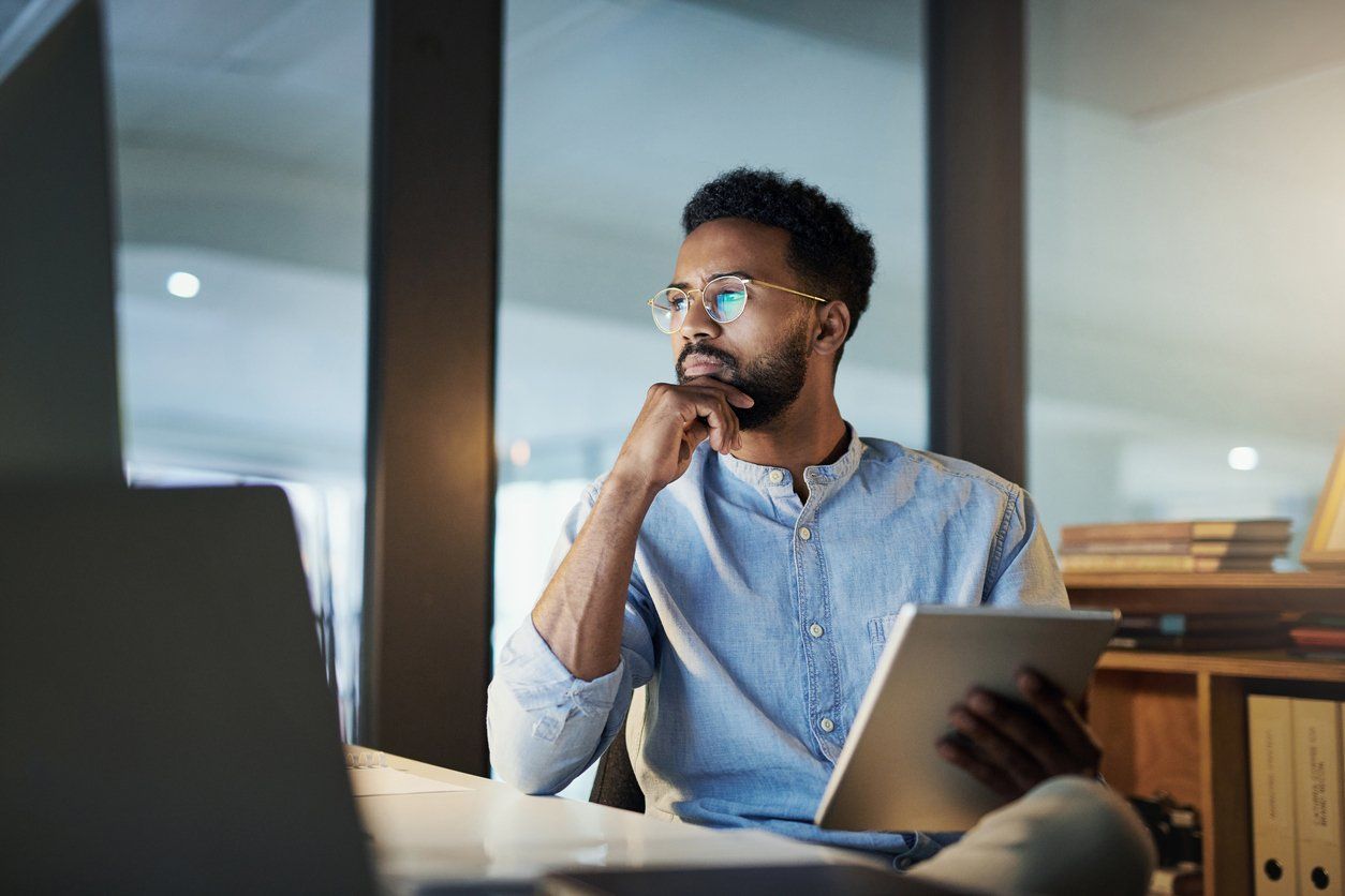 Entrepreneurship concept, businessman looking at a computer and tablet device while looking for business solutions.