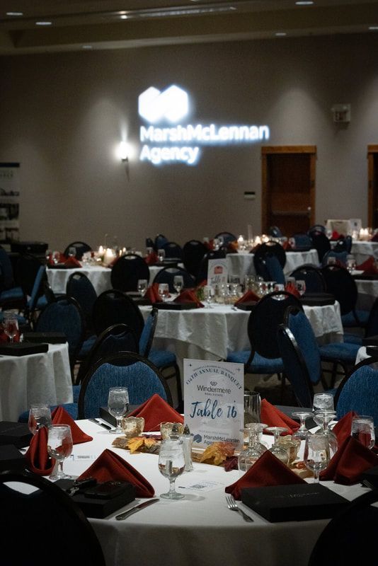 A room with tables and chairs set up for a marshmclannan agency event