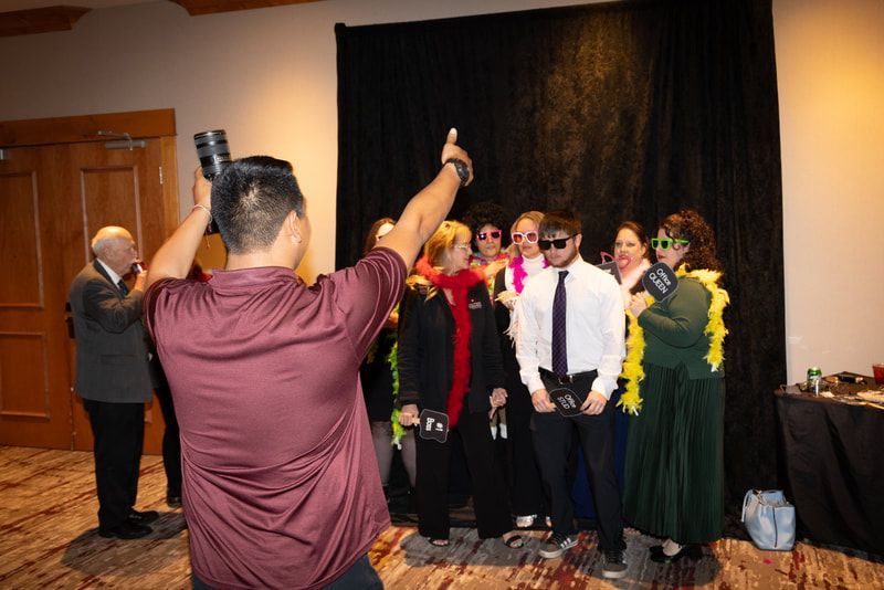 A man is taking a picture of a group of people in a photo booth.
