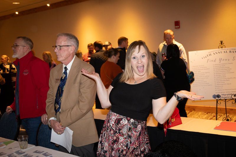 A woman is standing in front of a sign that says 