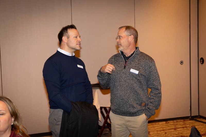 Two men are talking to each other in a room.