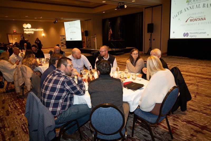 A group of people are sitting around a table in a room.