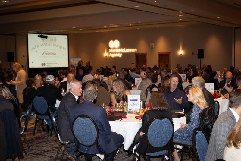 A large group of people are sitting at tables in a large room.