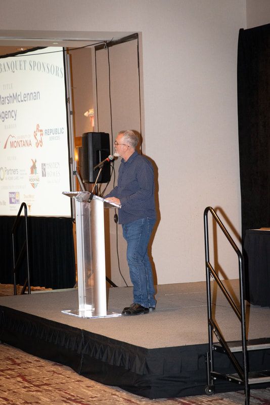 A man is standing at a podium giving a presentation