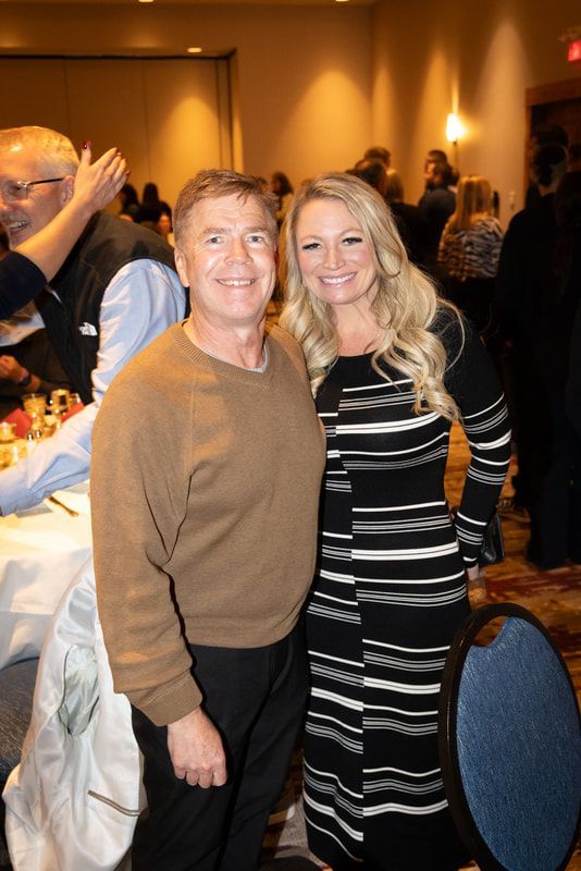 A man and a woman are posing for a picture in a room.