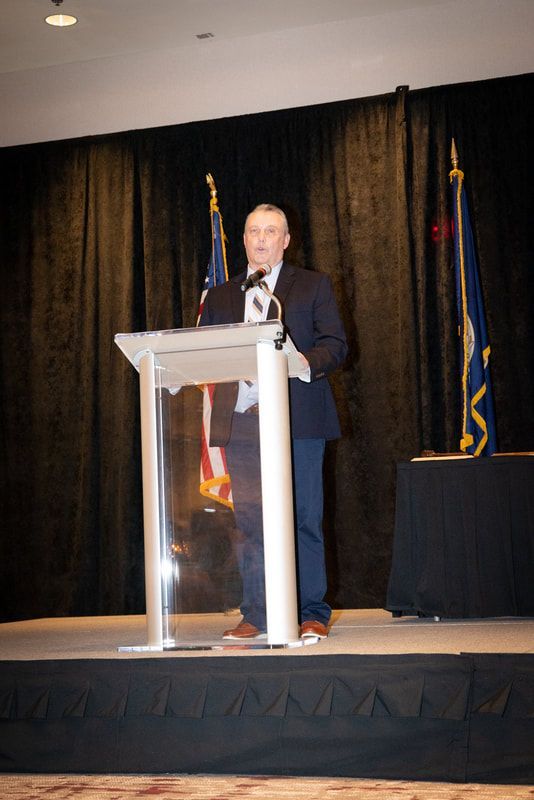 A man is standing at a podium giving a speech