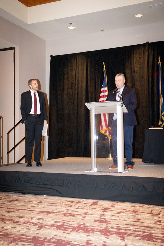 A man stands behind a podium giving a speech
