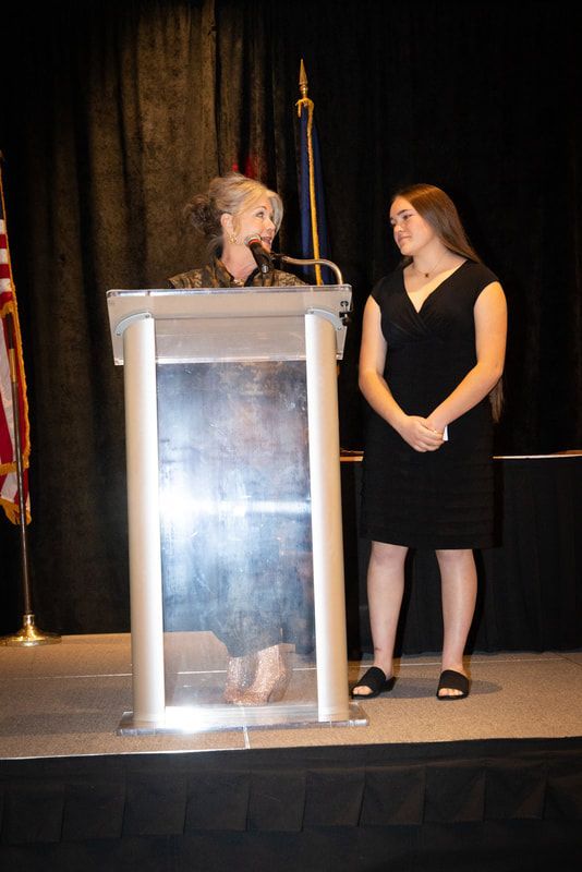 A woman is standing at a podium giving a speech