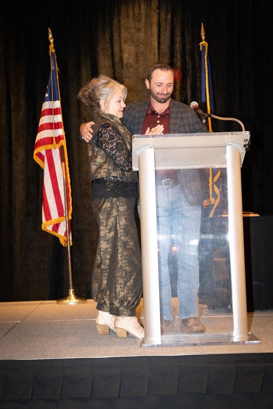 A man and a woman are standing next to each other at a podium.
