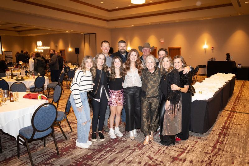A group of people are posing for a picture in a large room.