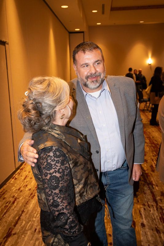 A man and a woman are standing next to each other in a hallway.