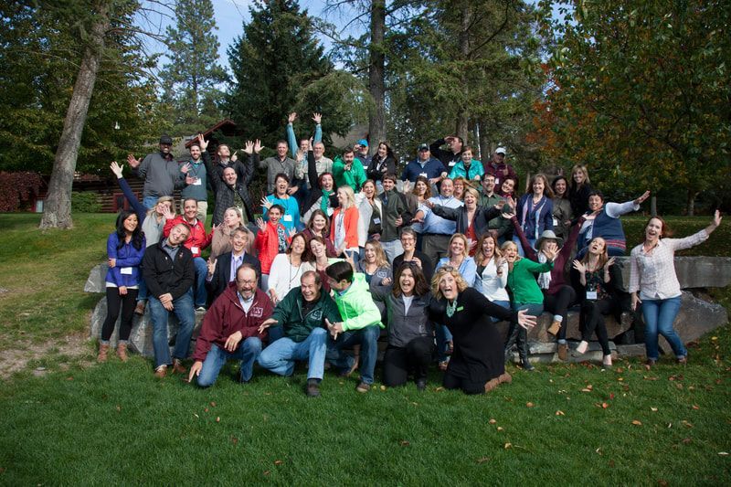 A large group of people are posing for a picture in a park.