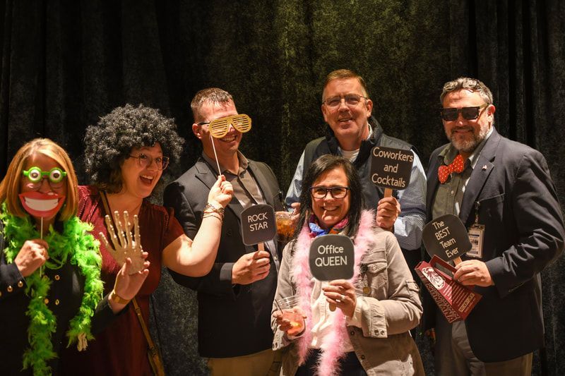 A group of people are posing for a picture in a photo booth.