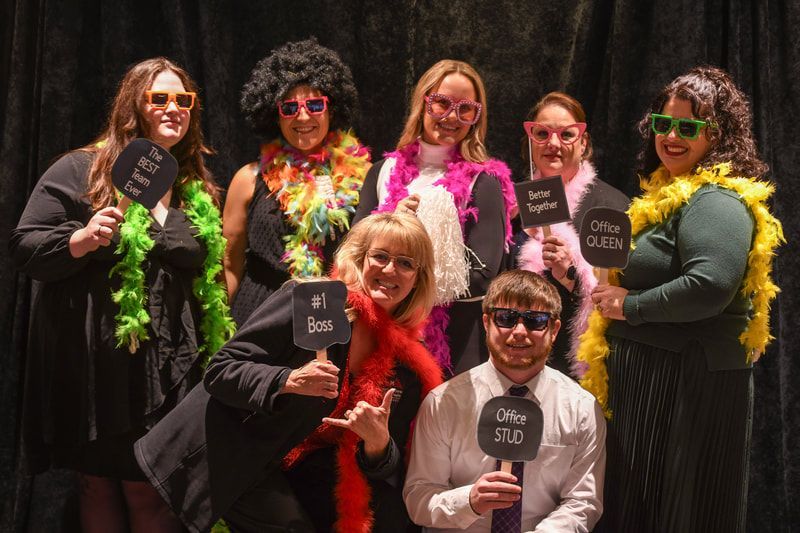 A group of people are posing for a picture and holding signs.