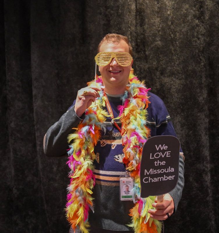 A man holding a sign that says we love the missoula chamber