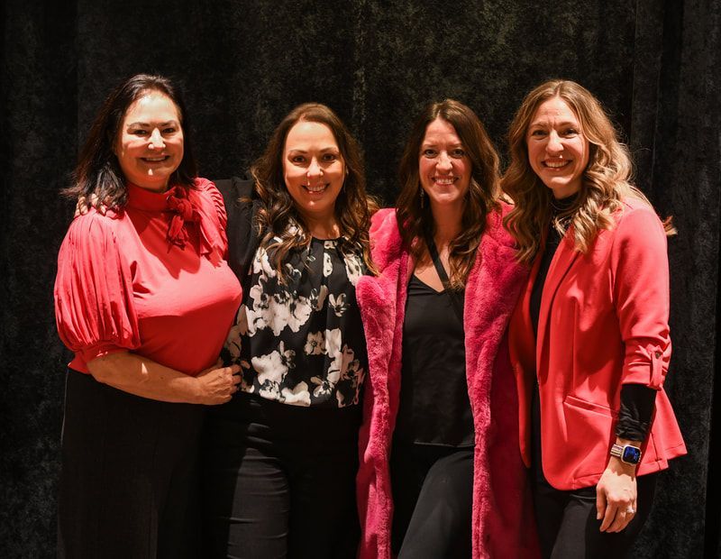 A group of women are posing for a picture together.
