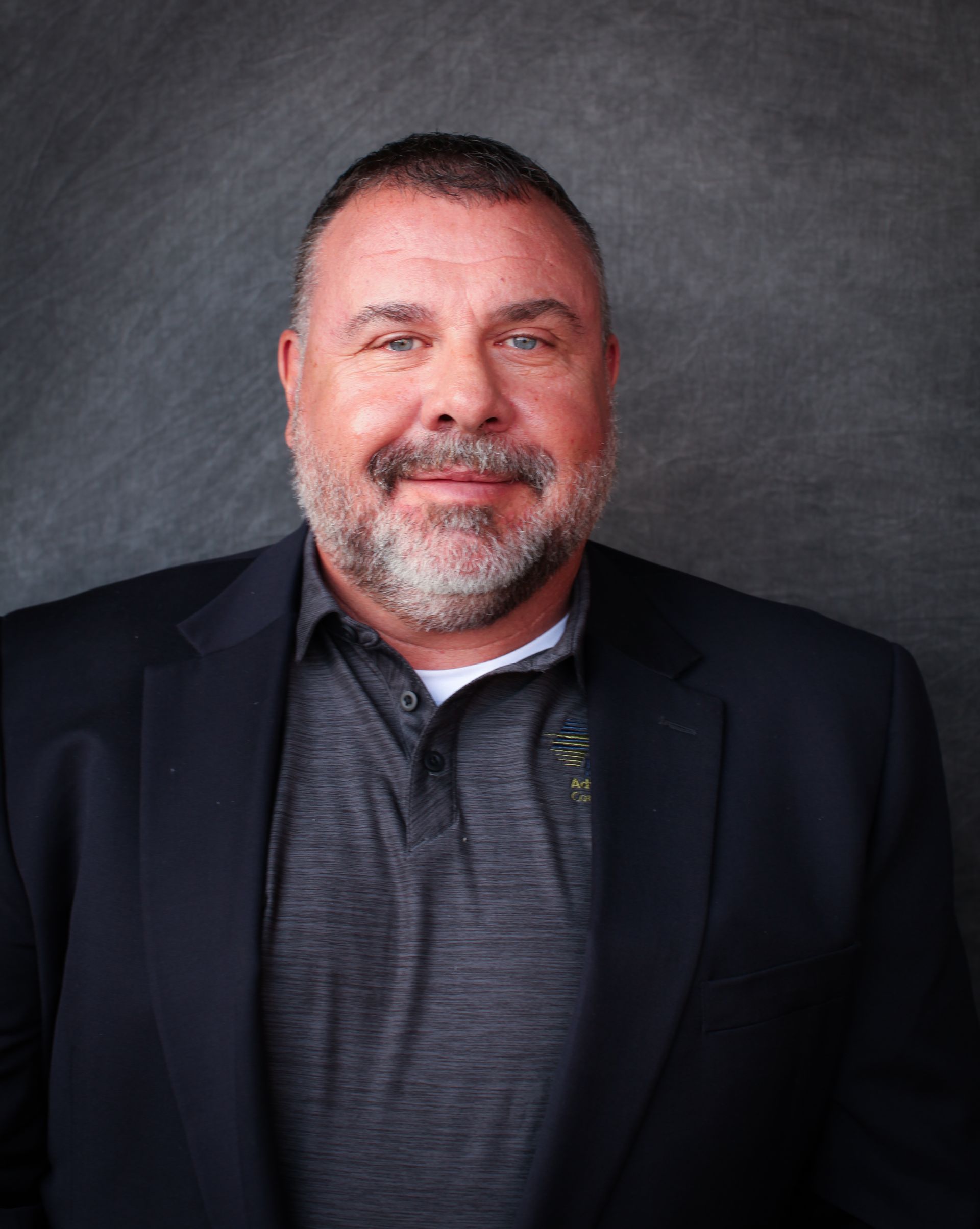 A man in a suit and tie is smiling for the camera