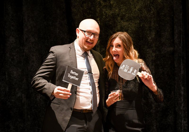 A man and a woman are posing for a picture while holding signs.