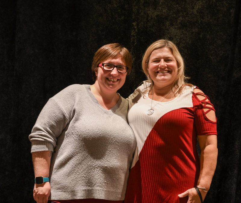 Two women are posing for a picture and one is wearing glasses