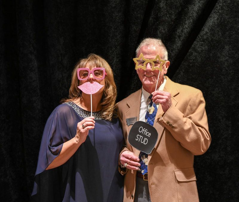 A man and a woman holding a sign that says office stud