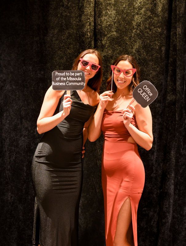 Two women are posing for a picture and one has a sign that says free queen