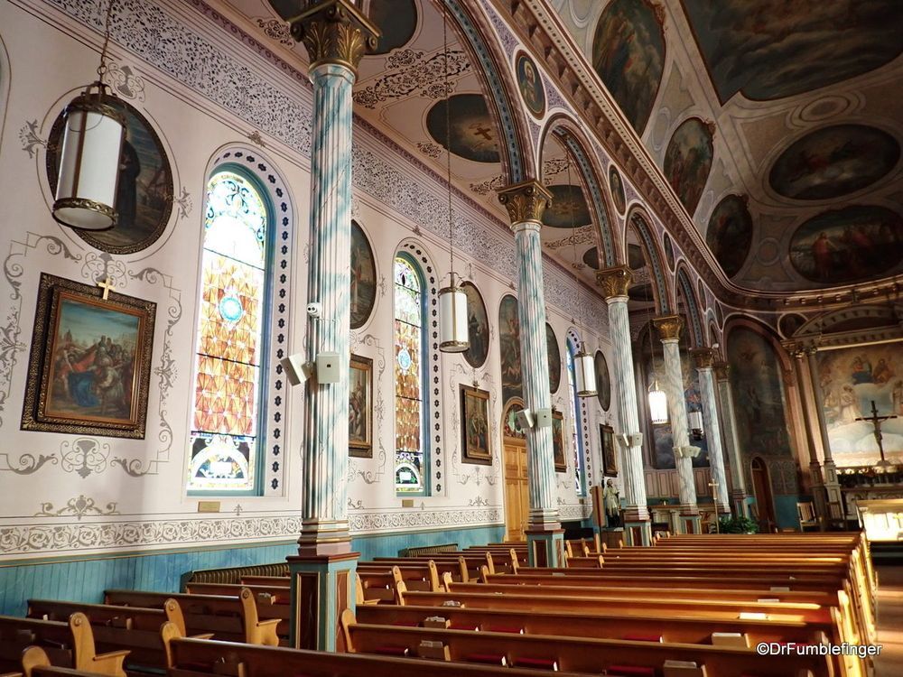 The inside of a church with wooden benches and stained glass windows