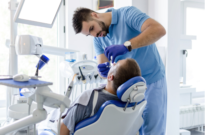 A dentist is examining a patient 's teeth in a dental office.