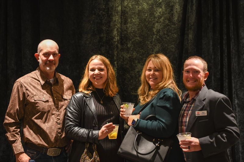 A group of people are posing for a picture while holding drinks.
