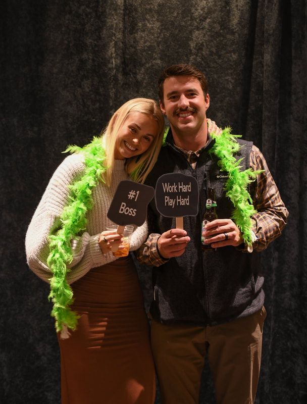 A man and a woman are posing for a picture while holding signs.