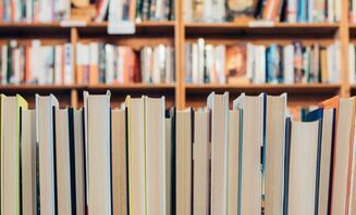 A row of books sitting on top of each other in a library.