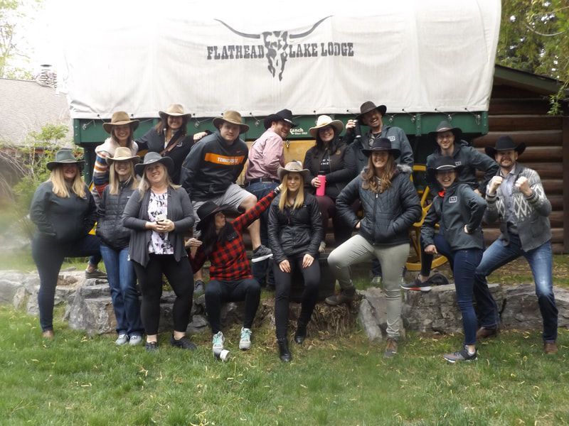 A group of people wearing cowboy hats are posing for a picture.