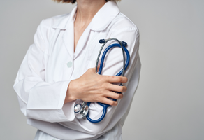 A female doctor is holding a stethoscope around her shoulder.