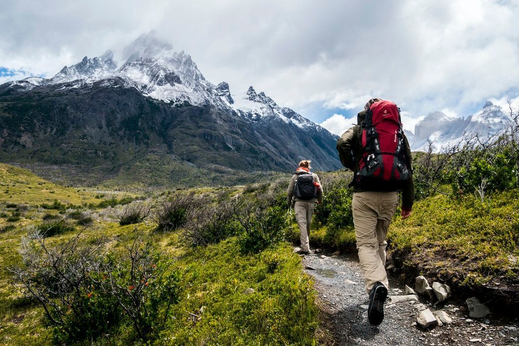 Two people are hiking in the mountains with backpacks.