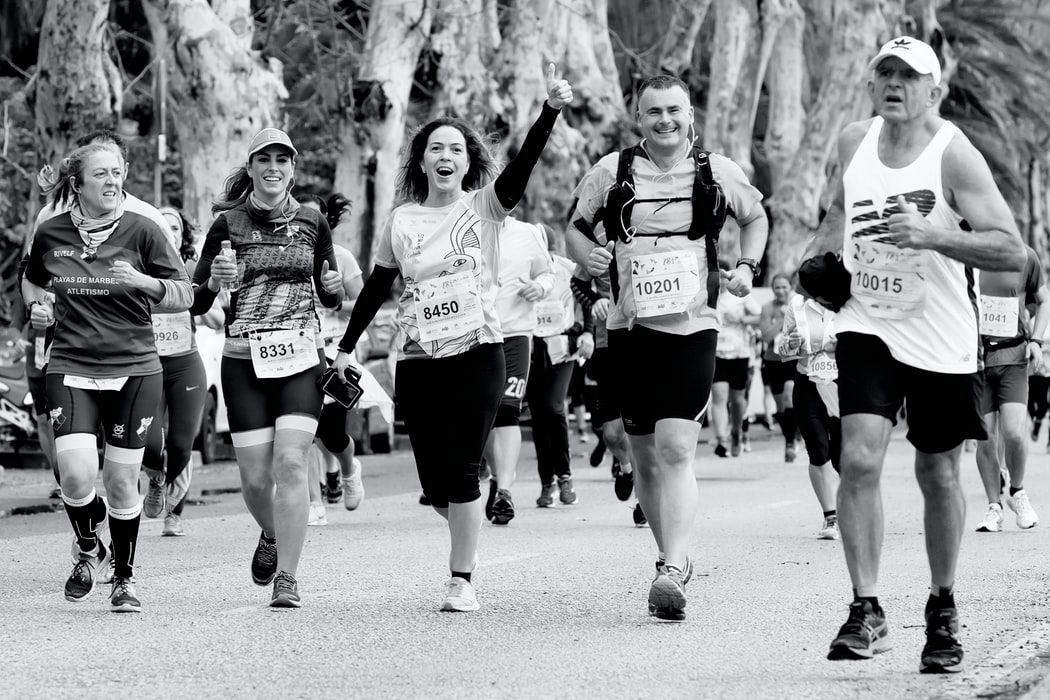 A black and white photo of a group of people running a marathon.